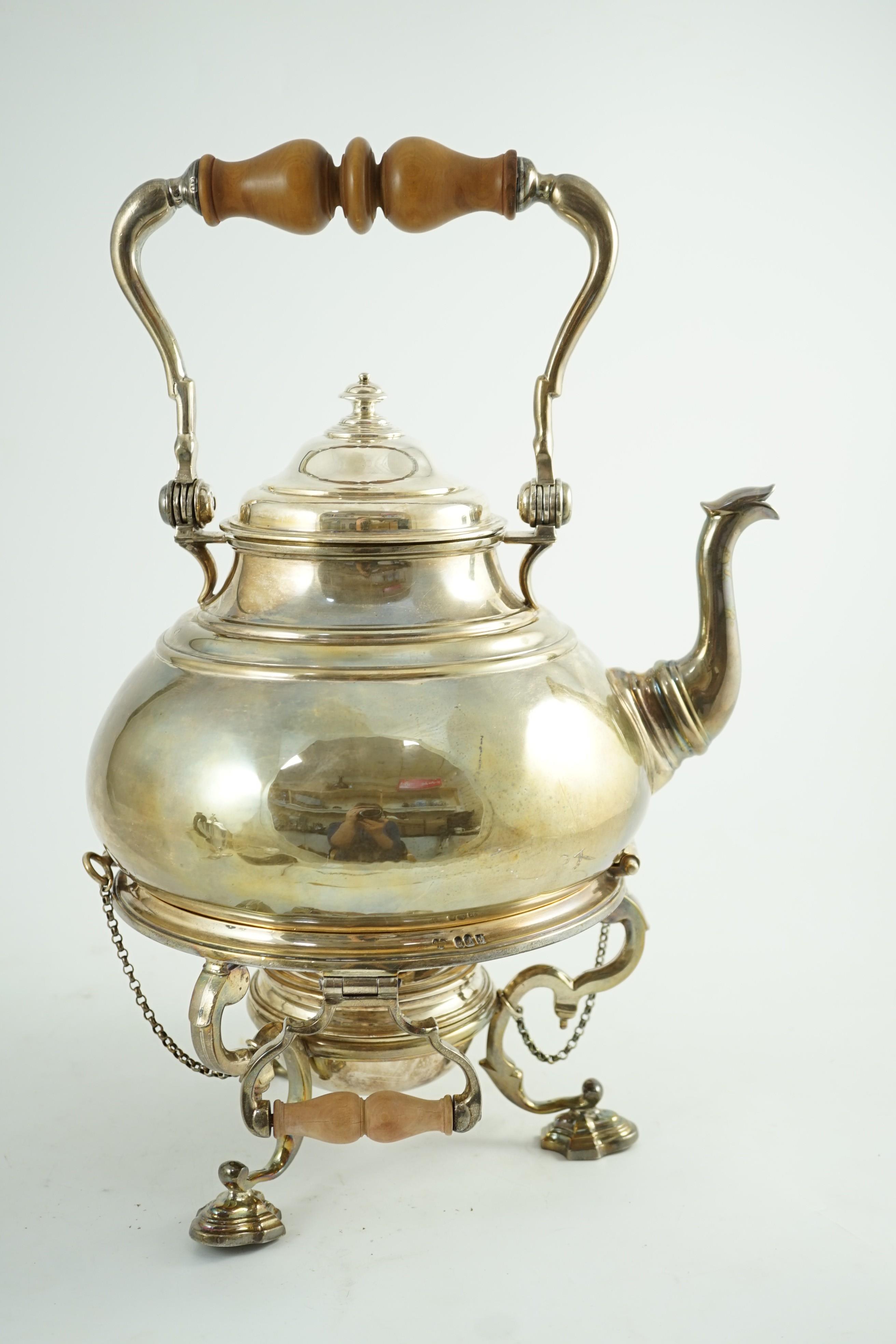 A large George V Britannia standard silver tea kettle on two handled stand, with burner, by Charles & Richard Comyns